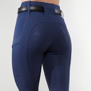 Rear view of navy riding leggings with a silicone grip seat, textured knee patch and side pocket, worn with a black belt.