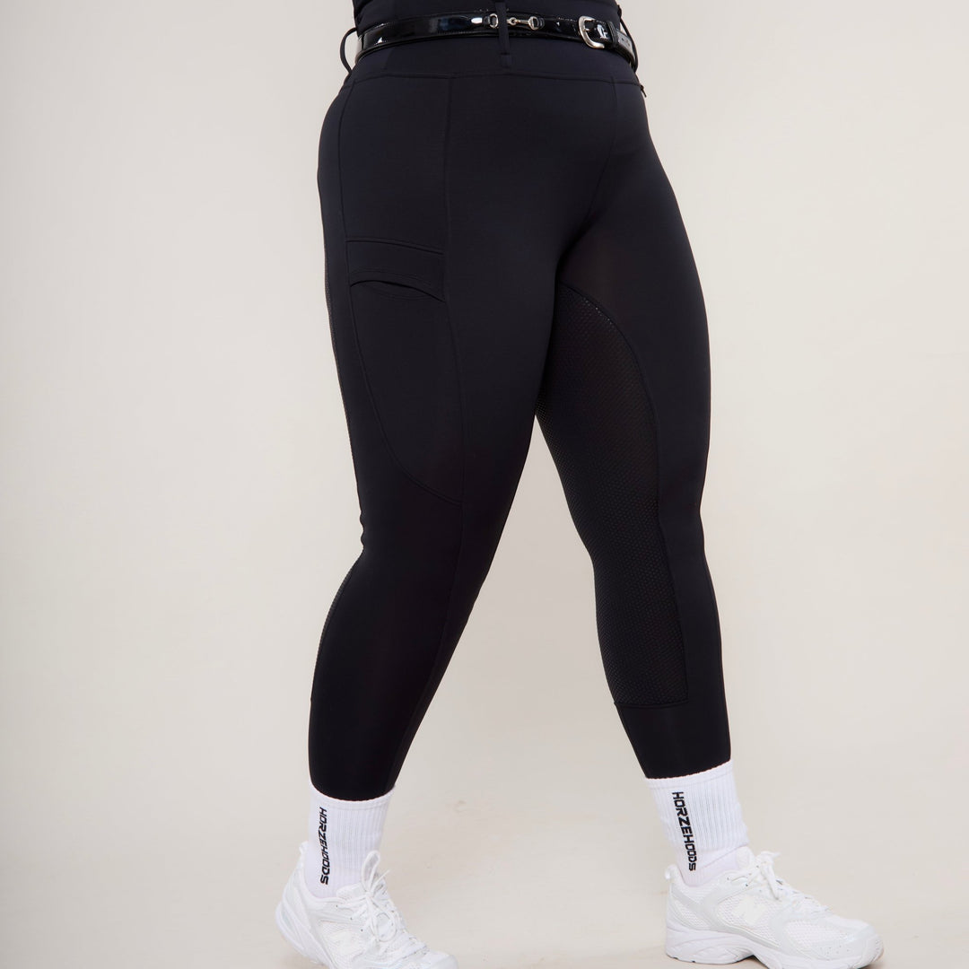 Side View of HORZEHOODS® Black Luxe Equestrian Riding Leggings showcasing high-waist design no grip option with trainers for a casual day look on a curvy play size model