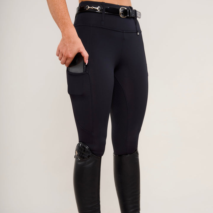 View demonstrating the use of phone pocket of HORZEHOODS® Black Luxe Equestrian Riding Leggings showcasing high-waist design