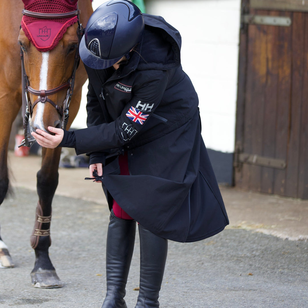 rider in the horzehoods ultimo riding coat stroking a horse